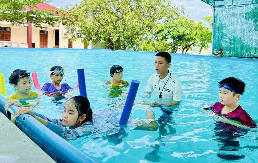 HLV Nguyễn Thành Lâm hướng dẫn thiếu nhi xã Tuy Phước Bắc kỹ năng bơi. Ảnh: Phan Lài 1-9995.jpg