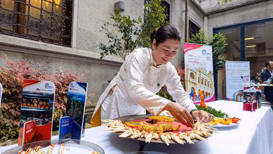 Nghệ nhân ưu tú Phan Tôn Gia Hiền cùng mâm bánh rồng giới thiệu ở MiLan, Ý. Ảnh: NVCC