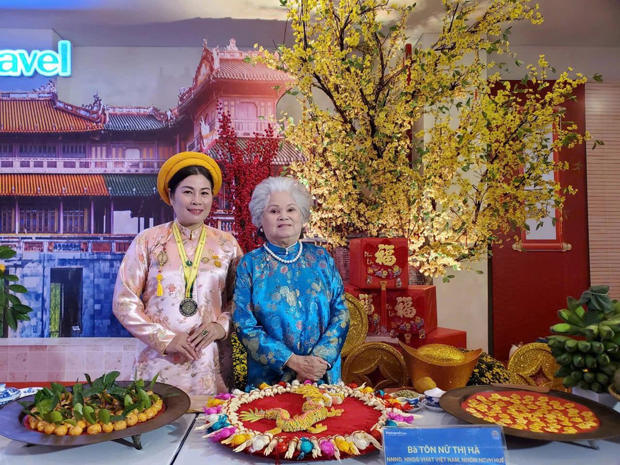 Nghệ nhân nhân dân Tôn Nữ Hà cùng con gái - nghệ nhân ưu tú Phan Tôn Gia Hiền với sản phẩm mâm bánh rồng. Ảnh: B.N.L