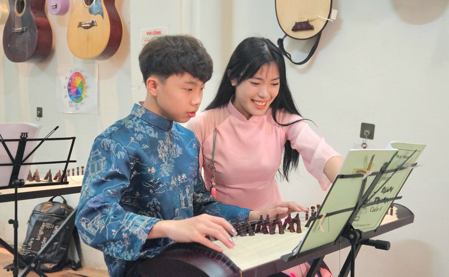 Em Cao Thái Sơn (bên trái) chăm chú lắng nghe cô giáo hướng dẫn tập đàn tranh tại Quynh Music House. Ảnh: Ngọc Duy tre-em.jpg