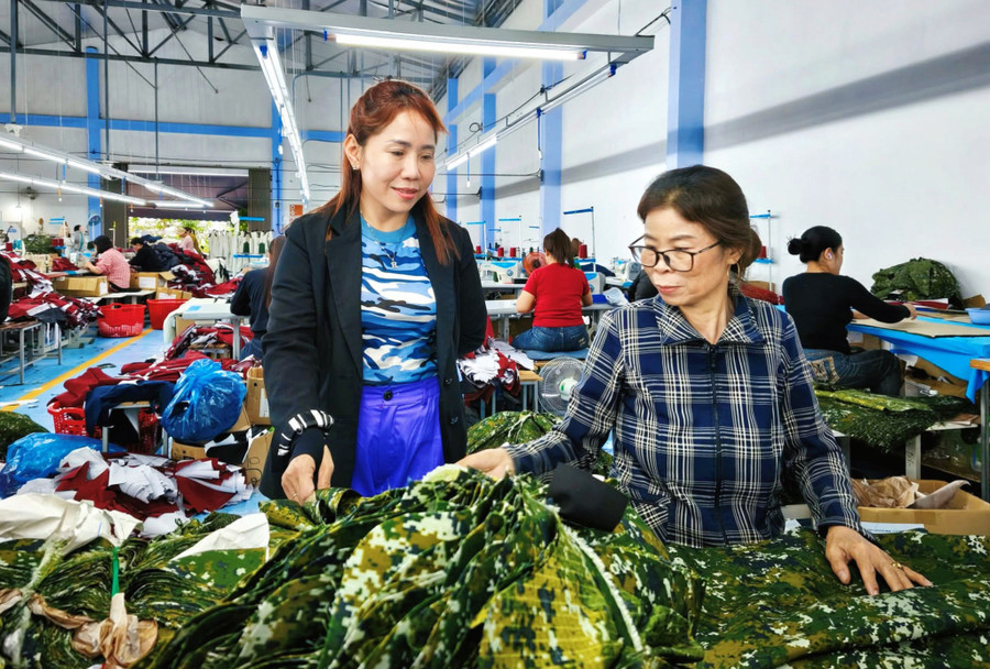 Chị Nguyễn Thị Kim Hân (bên trái, ở khối Phú Xuân, xã Tây Sơn) hướng dẫn lao động nữ làm việc tại cơ sở may của mình. Ảnh: Hải Yến ho-tro-phu-nu.jpg