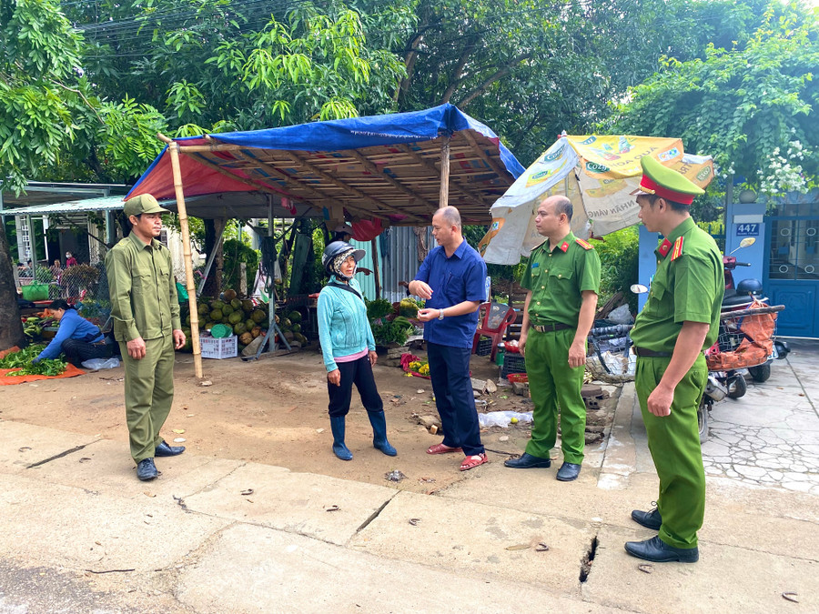 Ông Trần Minh Toàn, Phó Chủ tịch UBND xã Vân Canh (giữa) thuyết phục một tiểu thương quay trở lại chợ mới buôn bán. Ảnh: N.C trat-tu-buon-ban.jpg