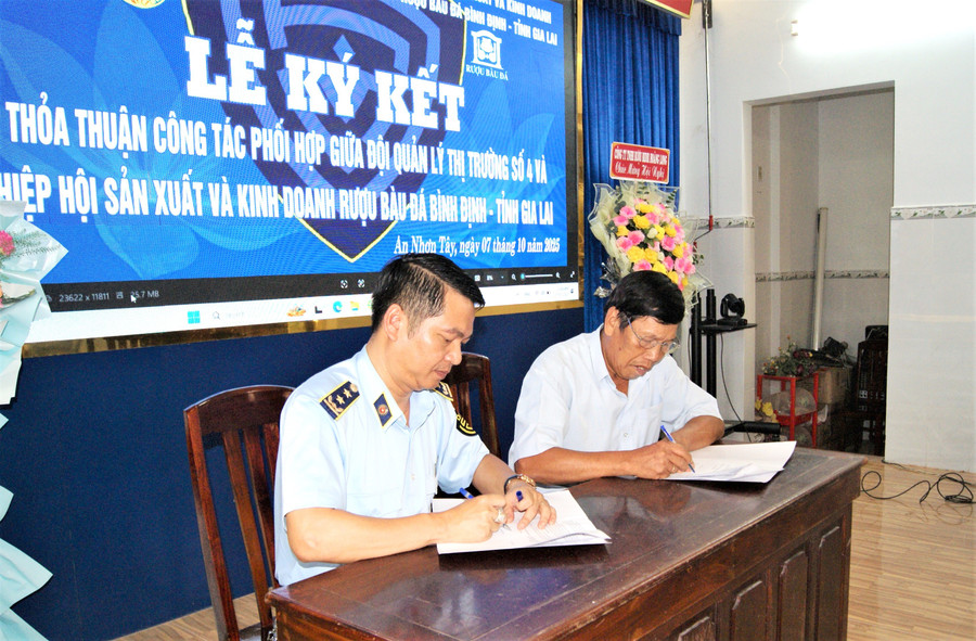 Đại diện các hộ dân, cơ sở sản xuất rượu thủ công thuộc Hiệp hội Sản xuất và kinh doanh rượu Bàu Đá Bình Định ký cam kết kinh doanh rượu theo đúng các quy định pháp luật. Ảnh: Văn Lực anh-1-ky-cam-ket.jpg