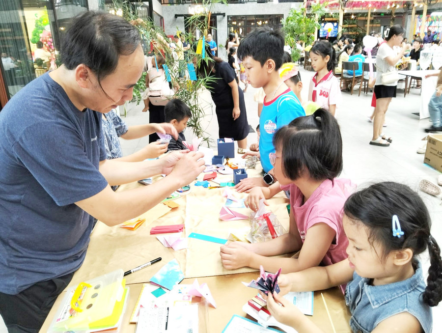 Hướng dẫn các em nhỏ gấp Origami. Ảnh: Văn Lực 5-day-gap-giay.jpg