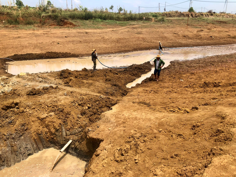 Người dân thôn Ia Mua (xã Bàu Cạn, huyện Chư Prông) đang phải kéo nước từ hồ khác về hồ Bầu Nai để lấy nước tưới cứu cây trồng. Ảnh: Lê Nam