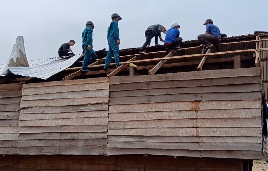 Lực lượng chức năng hỗ trợ người dân sửa chữa nhà ở bị tốc mái. Ảnh: Lê Nam