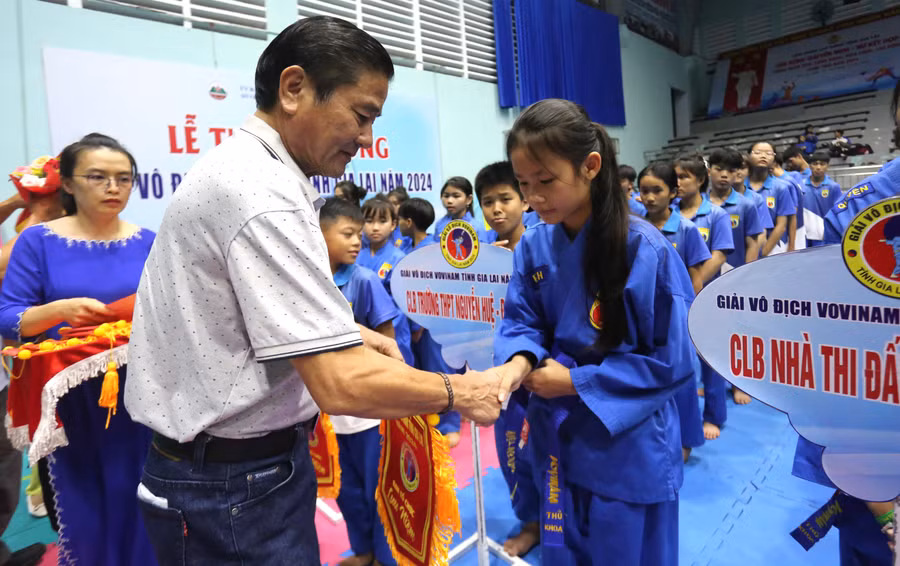 Giám đốc Sở Văn hóa-Thể thao và Du lịch Trần Ngọc Nhung (trái) tặng cờ lưu niệm cho các câu lạc bộ tham gia giải. Ảnh: Văn Ngọc