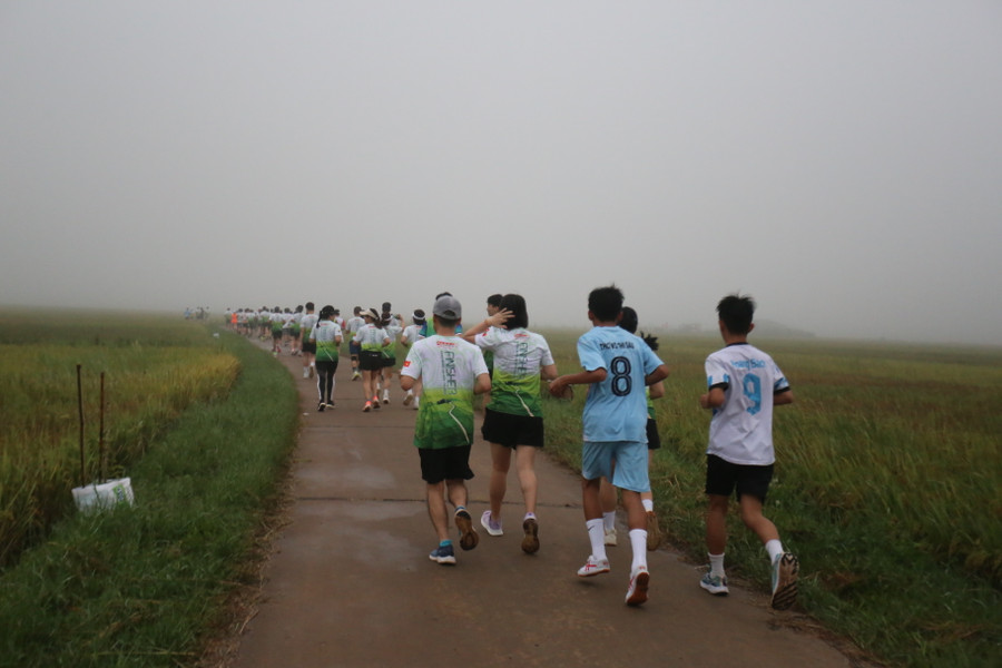 Đoàn người nối đuôi nhau chạy giữa sương mù ở cánh đồng. Ảnh: Văn Ngọc