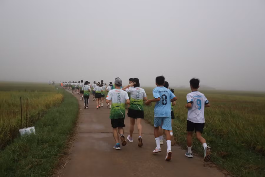 Đoàn người nối đuôi nhau chạy giữa sương mù ở cánh đồng. Ảnh: Văn Ngọc