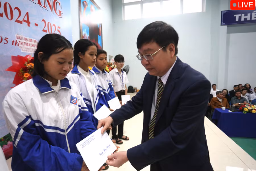 Trưởng Ban tổ chức Tỉnh ủy Huỳnh Quang Thái tặng 10 suất học bổng của cá nhân cho các em học sinh nghèo vượt khó. Ảnh: Văn Ngọc