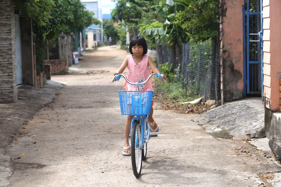 Ngọc Quỳnh tung tăng với chiếc xe đạp được Đội Cảnh sát Giao thông-Trật tự Công an thị xã Ayun Pa trao tặng. Ảnh: Văn Ngọc