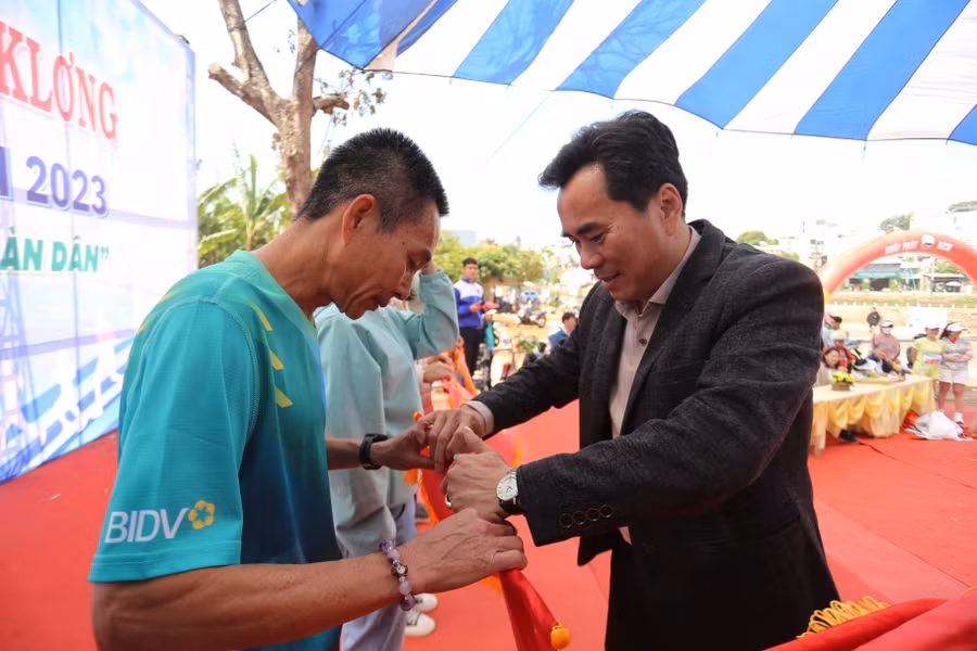 Phó Chủ tịch UBND TP. Pleiku Nguyễn Hữu Sung (phải) trao thưởng cho các đơn vị đạt giải toàn đoàn nam chính-nữ chính. Ảnh: Văn Ngọc