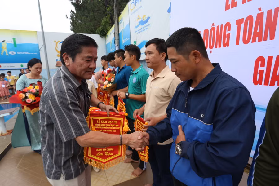 Ban tổ chức trao cờ lưu niệm cho các đơn vị tham gia buổi lễ. Ảnh: Văn Ngọc