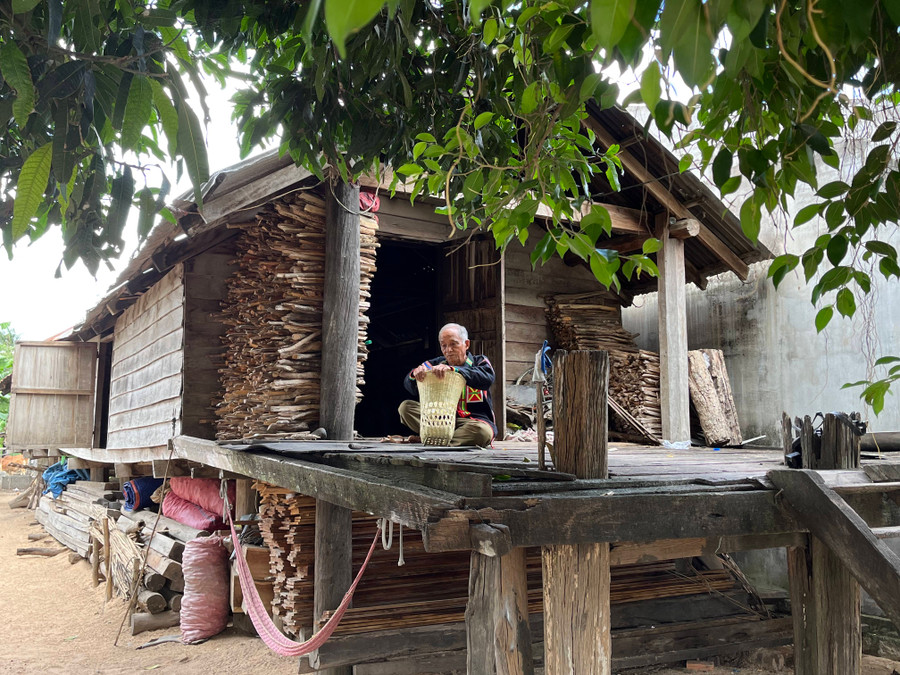 Mỗi lúc rảnh rỗi, ông Bốk lại ngồi bên hiên nhà sàn tranh thủ chuốt nan, đan gùi. Ảnh: P.L