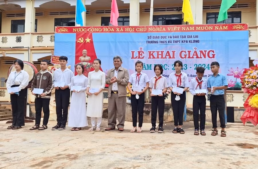 Ông Hồ Văn Điềm-Chủ tịch Ủy ban MTTQ Việt Nam tỉnh trao học bổng cho các học sinh có thành tích học tập tốt. Ảnh: Như Nguyện