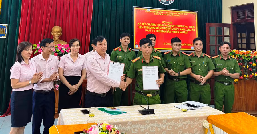 Lãnh đạo Công an huyện và Phòng Giao dịch NHCSXH huyện trao đổi nội dung ký kết. Ảnh: Minh Thoan