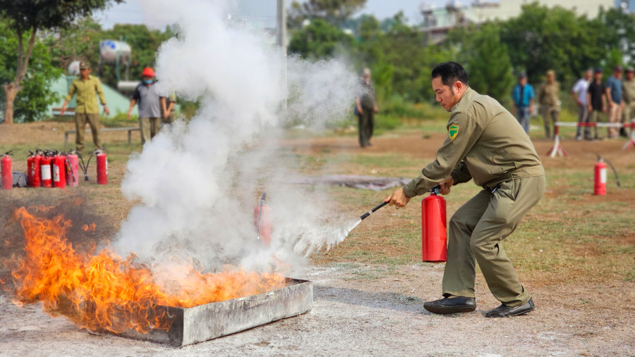 Các học viên thực hành dập tắt đám cháy bằng bình chữa cháy. Ảnh: Bá Bính