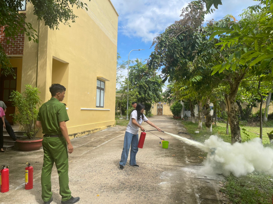 Thân nhân của các chiến sĩ thực hành dùng bình chữa cháy. Ảnh: Lệ Hằng