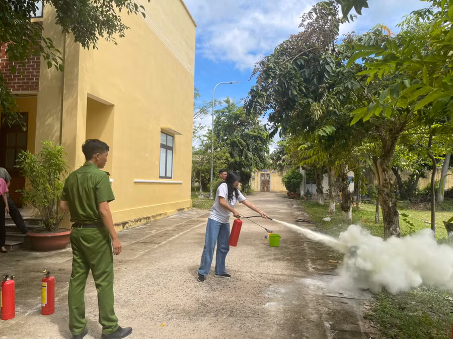 Thân nhân của các chiến sĩ thực hành dùng bình chữa cháy. Ảnh: Lệ Hằng