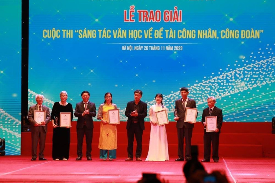 Nhà văn Phạm Đức Long (bìa phải) nhận giải ba thể loại tiểu thuyết tại lễ trao giải. Ảnh: Tùng Giang/Báo Lao Động