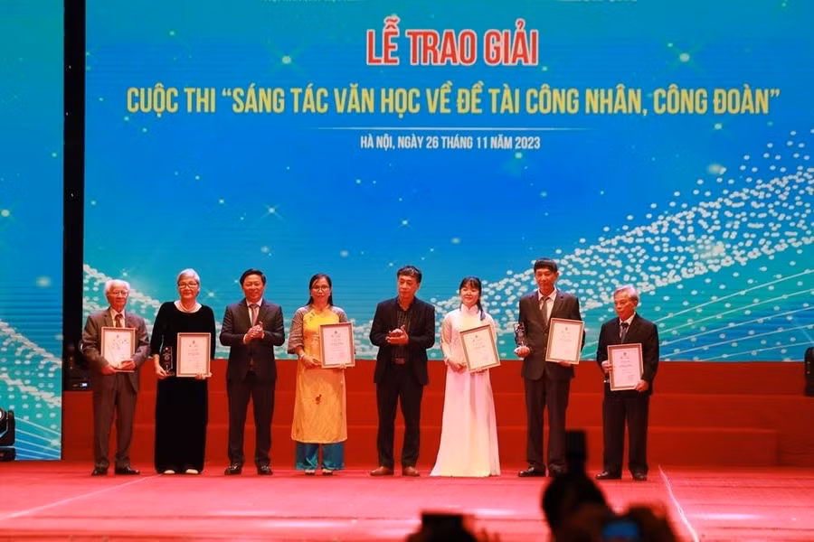 Nhà văn Phạm Đức Long (bìa phải) nhận giải ba thể loại tiểu thuyết tại lễ trao giải. Ảnh: Tùng Giang/Báo Lao Động