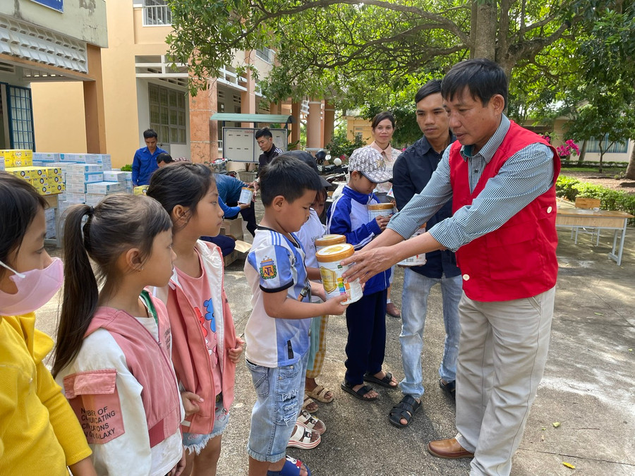 Lãnh đạo Hội Chữ thập đỏ huyện Kông Chro tặng sữa cho các em học sinh. Ảnh: Phương Liên