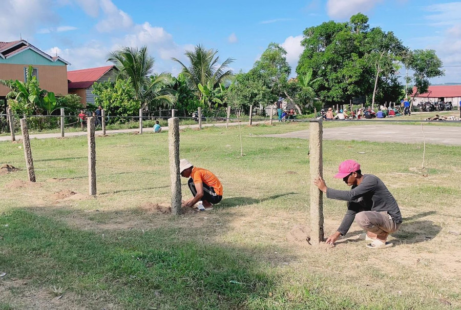 Đoàn viên thanh niên và bà con trong thôn cùng nhau làm hàng rào khu vực nhà rông của thôn Plei Trớ. Ảnh: Hoa Mai