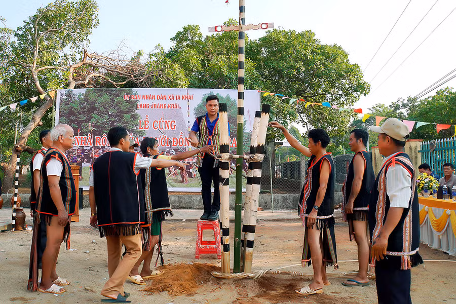 Già làng, người uy tín trong làng cùng nhau dựng cây nêu mới trước nhà rông. Ảnh: Đức Thụy