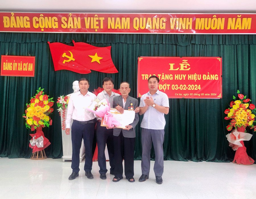 Lãnh đạo Huyện ủy Đak Pơ và Đảng ủy xã Cư An trao quyết định và huy hiệu đảng 75 năm cho đảng viên Trương Thạnh. Ảnh: Lan Anh