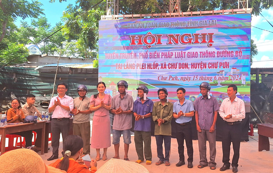 Ban tổ chức tặng mũ bảo hiểm cho người dân tham gia tại hội nghị. Ảnh: Hồng Duyên