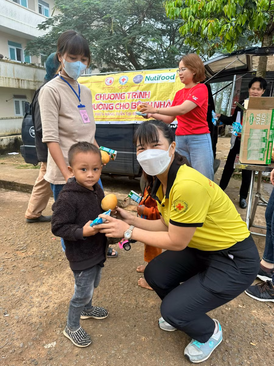 Các thành viên Câu lạc bộ Máu nóng Gia Lai trao tặng bánh mì và sữa cho các bệnh nhi. Ảnh: M.N