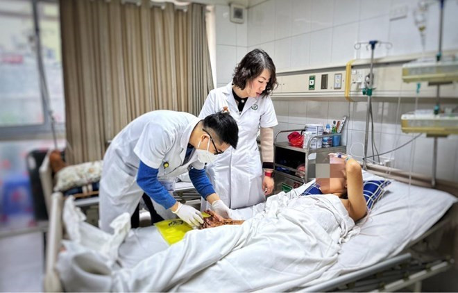 Các bác sĩ Bệnh viện Hữu nghị Việt Đức thăm khám cho bệnh nhân bị dập nát tay do pháo nổ tự chế. Ảnh nguồn Báo Lao Động Các bác sĩ Bệnh viện Hữu nghị Việt Đức thăm khám cho bệnh nhân bị dập nát tay do pháo nổ tự chế. Ảnh nguồn Báo Lao Động