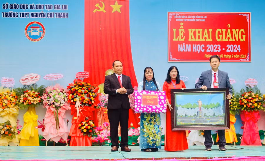 Phó Bí thư Tỉnh ủy Rah Lan Chung (bìa trái) tặng quà cho Trường THPT Nguyễn Chí Thanh. Ảnh: Phan Lài