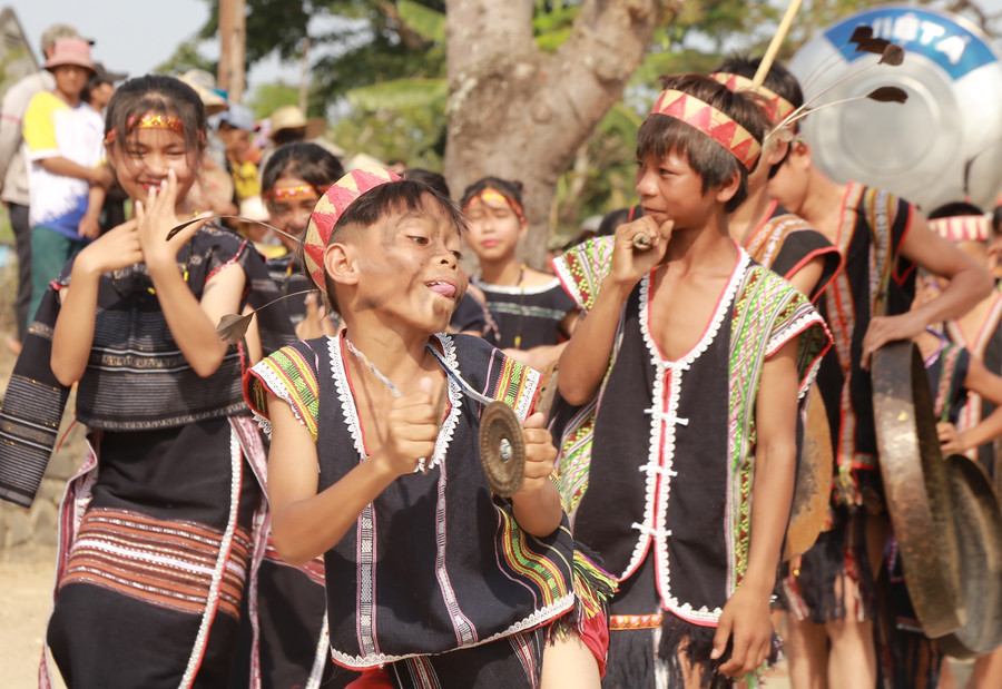 Cậu bé Đinh Minh đảm nhận vai trò pơtual trong đội cồng chiêng biểu diễn tại lễ cúng. Ảnh: Phương Linh