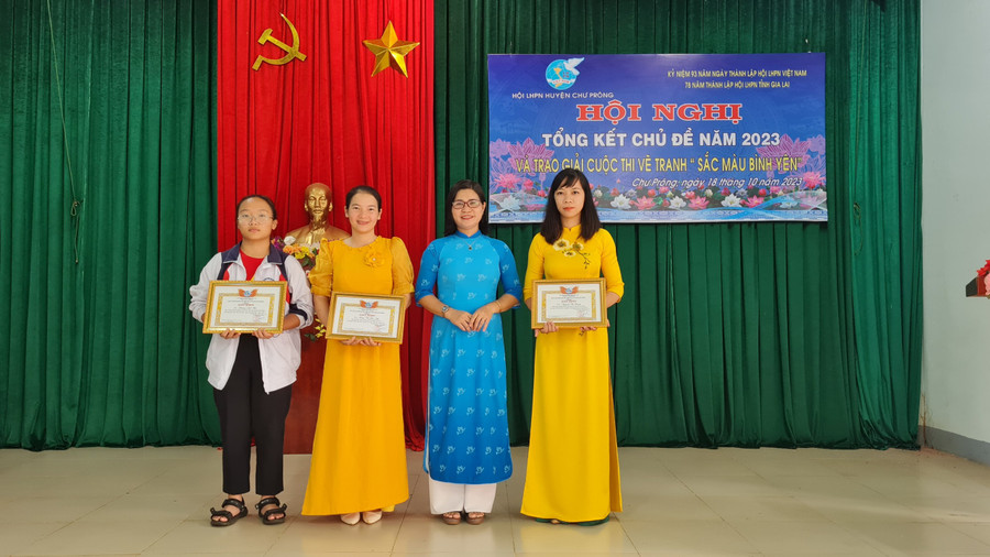 Chị Siu H&apos;Thoan-Chủ tịch Hội LHPN huyện Chư Prông (thứ 2 từ phải sang) trao giải nhất, nhì, ba cho các thí sinh đoạt giải cuộc thi vẽ tranh &quot;Sắc màu bình yên&quot;. Ảnh: Khánh Linh