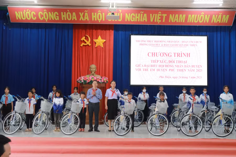Bí thư Huyện ủy Phú Thiện Nguyễn Hoàng Phong trao phần quà xe đạp cho các em học sinh vượt khó học giỏi do Phó Chủ tịch Thường trực HĐND tỉnh Trương Văn Đạt gửi tặng. Ảnh: Hoa Mai