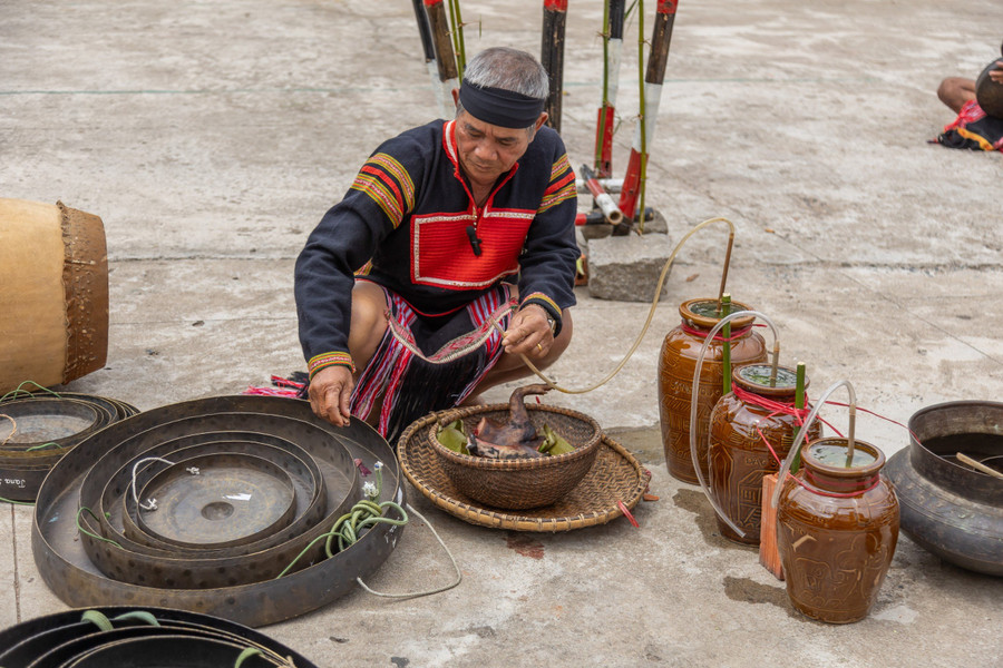 Già Hoăt vừa đặt lễ vật vào từng chiếc chiêng mới vừa khấn các vị thần linh về chứng giám.