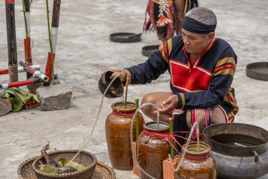 Già Hoăt đổ nước vào ghè rượu, mở đầu nghi thức của lễ cúng.