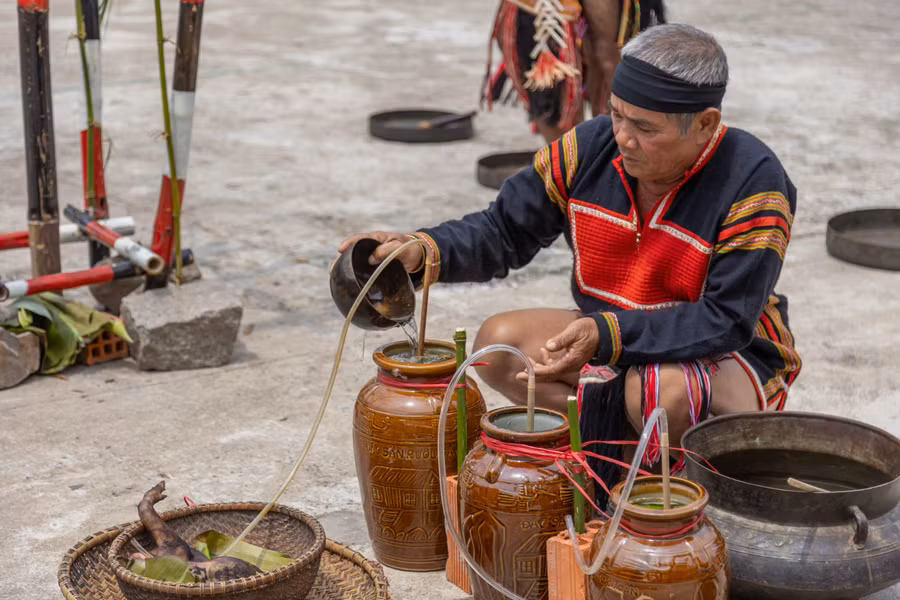 Già Hoăt đổ nước vào ghè rượu, mở đầu nghi thức của lễ cúng.