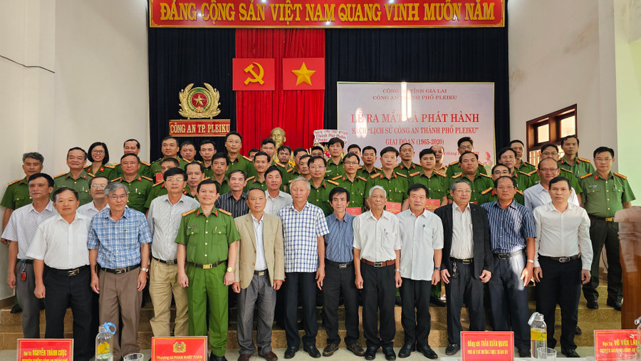 Các đại biểu chụp hình lưu niệm và trao tặng cuốn sách “Lịch sử Công an TP. Pleiku”. Ảnh: Bá Bính