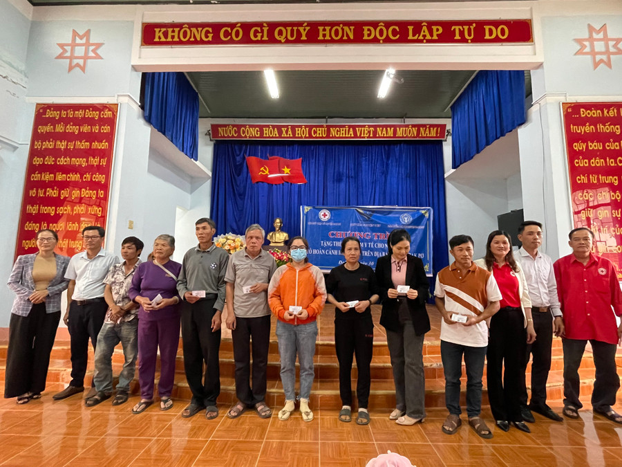 Đại diện Hội Chữ thập đỏ và Bảo hiểm xã hội huyện Đak Pơ tặng thẻ bảo hiểm cho người khó khăn trên địa bàn thị trấn Đak Pơ. Ảnh: Tuyết Mai