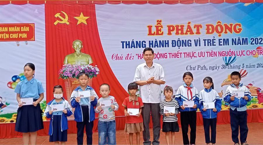 Lãnh đạo UBND huyện Chư Pưh trao quà cho các em thiếu nhi. Ảnh: Minh Hải