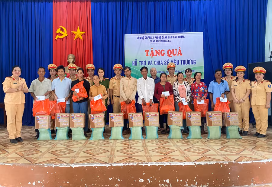 Cán bộ, chiến sĩ Phòng Cảnh sát Giao thông Công an tỉnh trao quà cho các hộ dân khó khăn. Ảnh: Nguyễn Sang