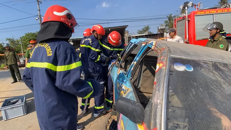 Lực lượng chức năng sử dụng thiết bị chuyên dụng phá cửa xe cứu nạn nhân tại buổi diễn tập. Ảnh: Nguyễn Sang