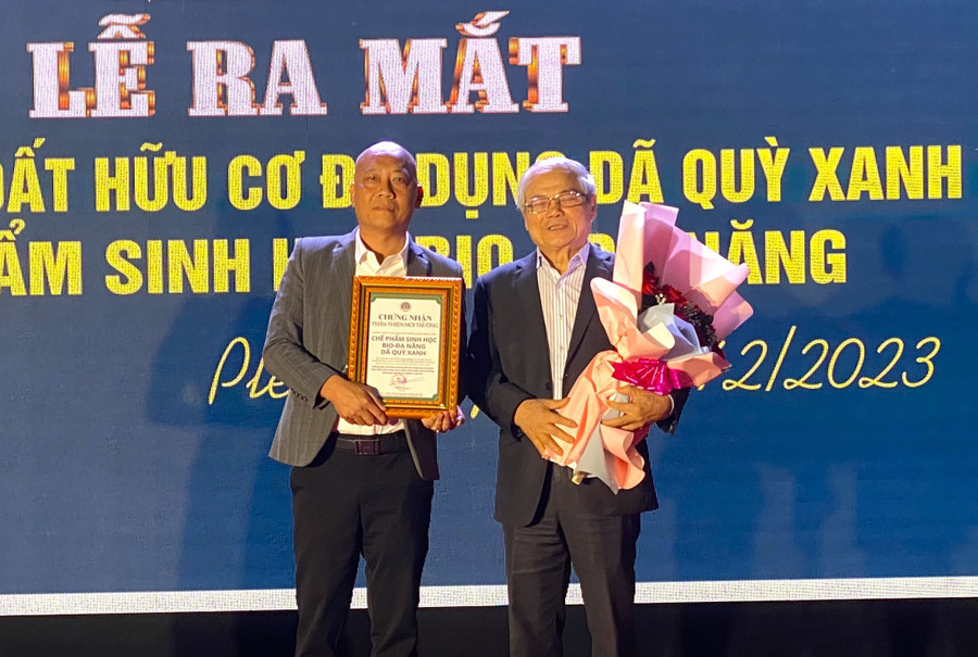 Tiến sĩ Lê Văn Tri-Viện trưởng Viện Khoa học Công nghệ Sinh học và Môi trường (bìa phải) trao giấy chứng nhận sản phẩm cho Hợp tác xã Nông nghiệp và Du lịch Chư Á. Ảnh: Hà Đức Thành