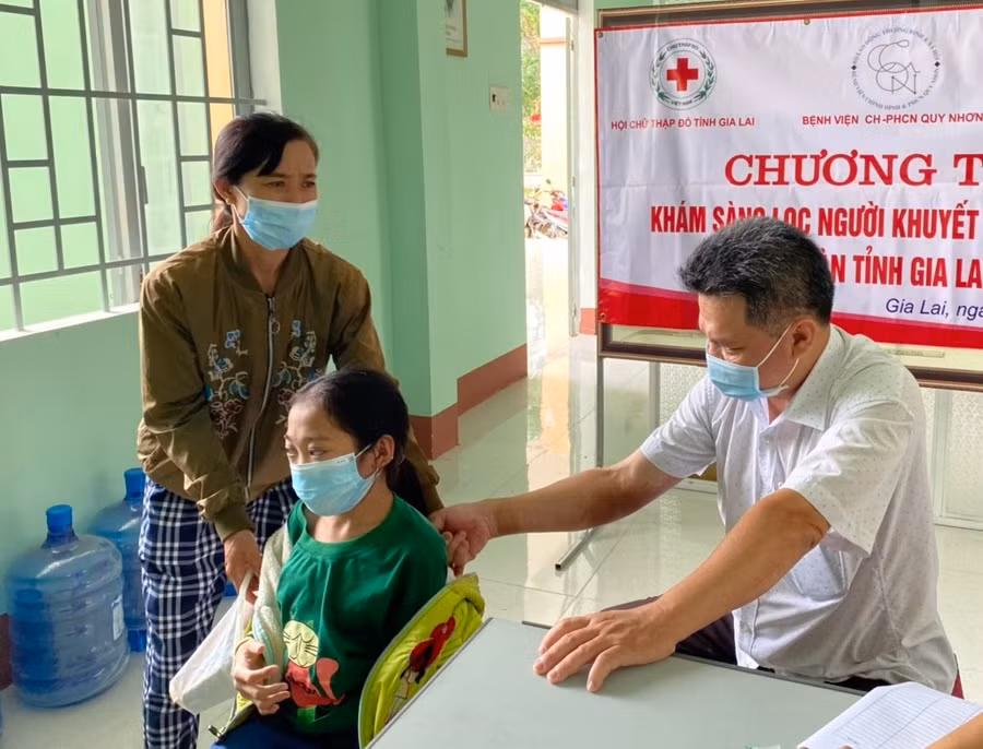 Các bác sĩ khám sàng lọc miễn phí cho trẻ em là người khuyết tật hệ vận động ở huyện Đak Pơ. Ảnh: Hồng Ngọc