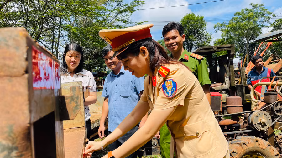 Cán bộ Công an TP. Pleiku dán phản quang cho xe công nông của người dân. Ảnh: Bá Bính