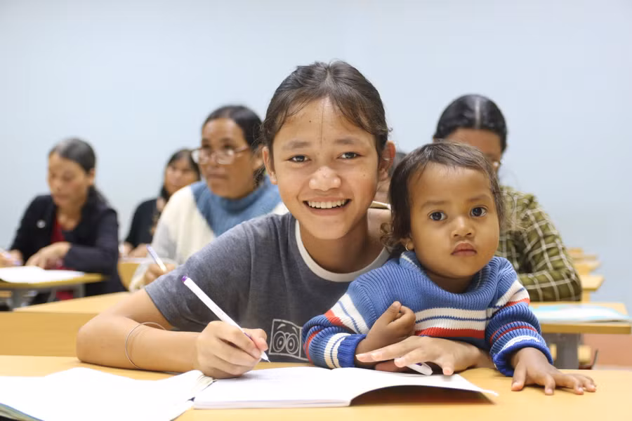 Em H’Ý (lớp 3, Trường Tiểu học Ngô Quyền, phường Chi Lăng) cũng đến lớp để được phụ đạo thêm kiến thức. Vừa học em vừa tranh thủ trông em nhỏ.