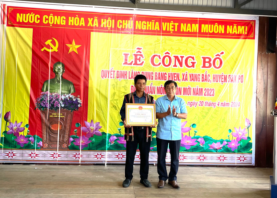 Ông Huỳnh Văn Hơn-Phó chủ tịch UBND huyện Đak Pơ (bìa phải) trao bằng công nhận làng nông thôn mới cho bà con làng Bung Bang Hven. Ảnh: Tuyết Mai