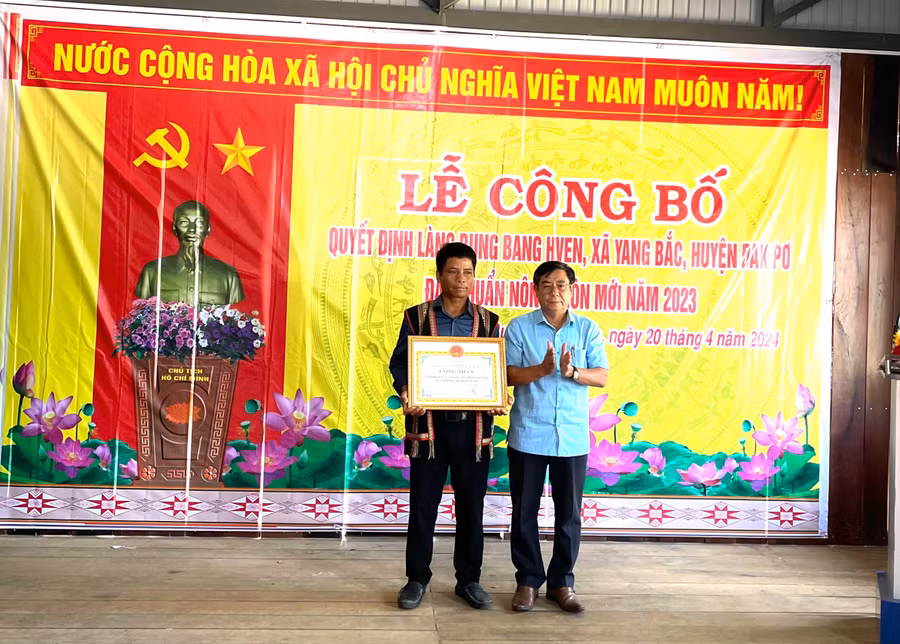 Ông Huỳnh Văn Hơn-Phó chủ tịch UBND huyện Đak Pơ (bìa phải) trao bằng công nhận làng nông thôn mới cho bà con làng Bung Bang Hven. Ảnh: Tuyết Mai